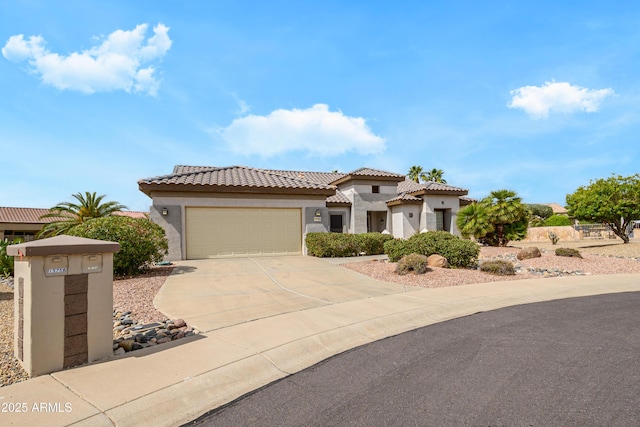 mediterranean / spanish home with concrete driveway, a tiled roof, a garage, and stucco siding