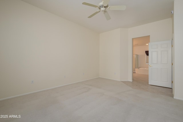 spare room with light colored carpet, baseboards, and ceiling fan