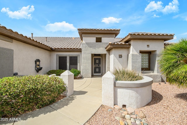 view of front of home with stucco siding and a tiled roof