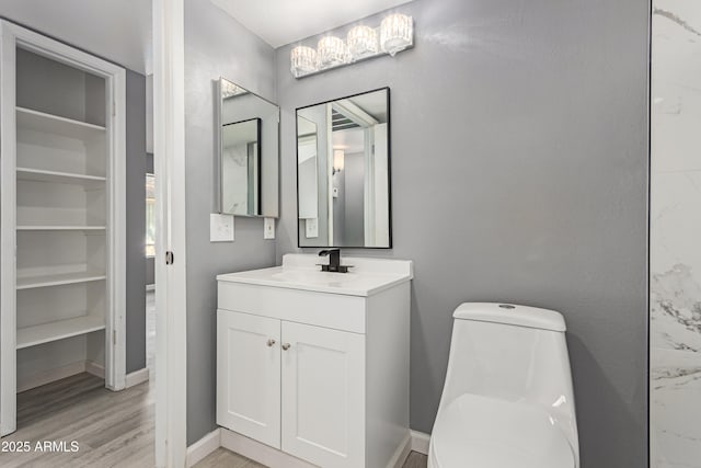 bathroom featuring wood-type flooring, vanity, and toilet