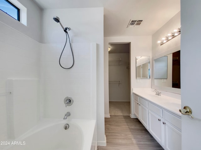 bathroom featuring tub / shower combination, vanity, and wood-type flooring