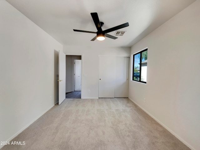 unfurnished bedroom with ceiling fan and light colored carpet