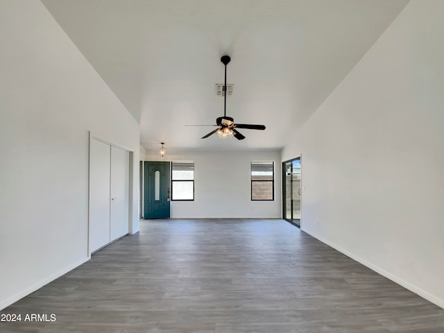 unfurnished living room featuring hardwood / wood-style floors, a high ceiling, and ceiling fan