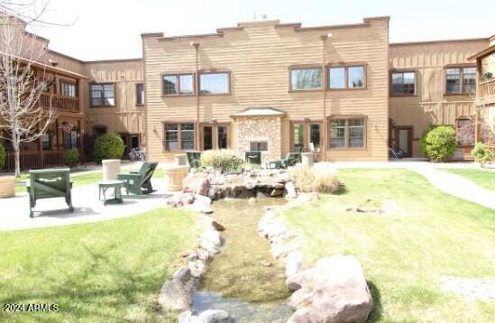 back of house featuring a patio area and a lawn