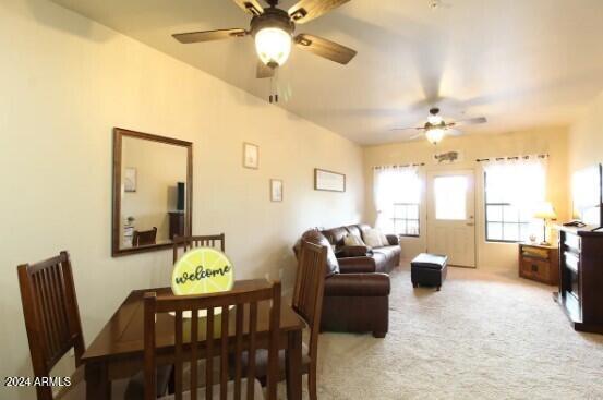 carpeted dining space featuring ceiling fan