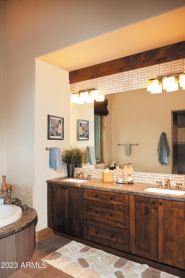 bathroom with tiled tub, vanity, and tile patterned floors