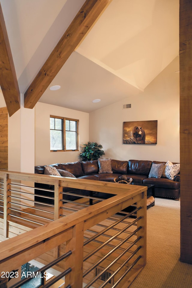 carpeted living room featuring lofted ceiling with beams