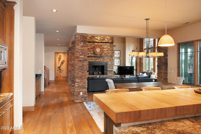 interior space with a stone fireplace and light hardwood / wood-style floors