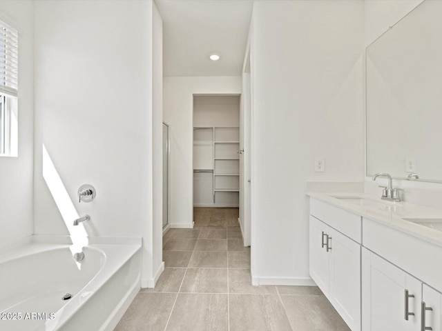 4041 S 176th Dr, Goodyear, AZ 85338 - full bathroom with a bath, double vanity, a shower stall, tile patterned floors, and a spacious closet