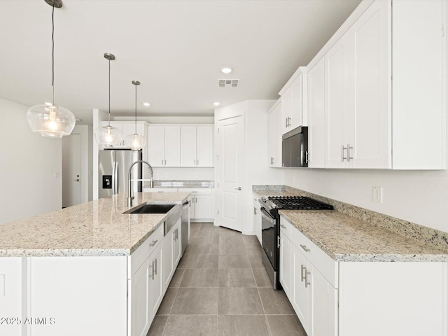 4041 S 176th Dr, Goodyear, AZ 85338 - kitchen with stainless steel appliances, white cabinets, a kitchen island with sink, hanging light fixtures, and recessed lighting