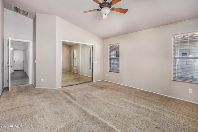 unfurnished bedroom with baseboards, visible vents, vaulted ceiling, carpet flooring, and a closet