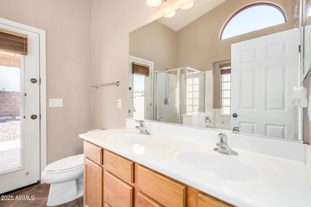 bathroom featuring toilet, tile patterned flooring, a shower stall, and a sink