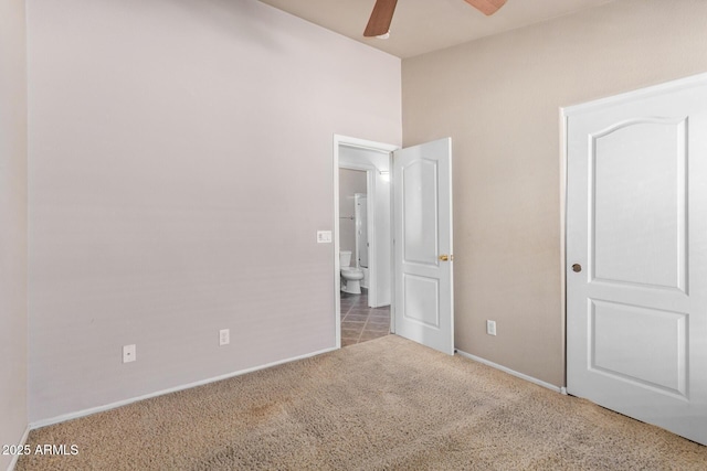 unfurnished bedroom with carpet flooring, a ceiling fan, and baseboards