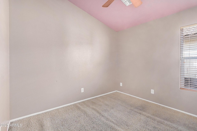 carpeted empty room with a ceiling fan and baseboards