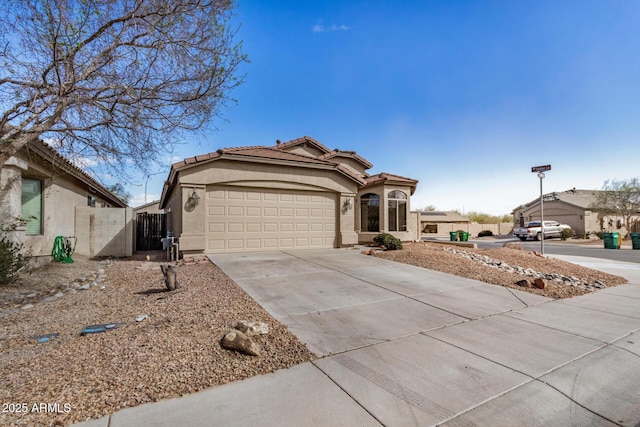 view of front of property featuring stucco siding, fence, a garage, driveway, and a tiled roof