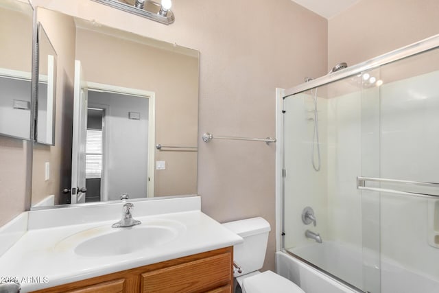 full bath with shower / bath combination with glass door, vanity, and toilet