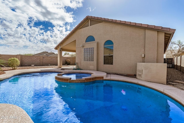 view of swimming pool with a pool with connected hot tub and a fenced backyard