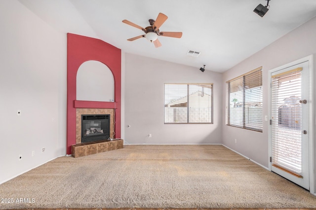 unfurnished living room featuring lofted ceiling, a fireplace, visible vents, and carpet