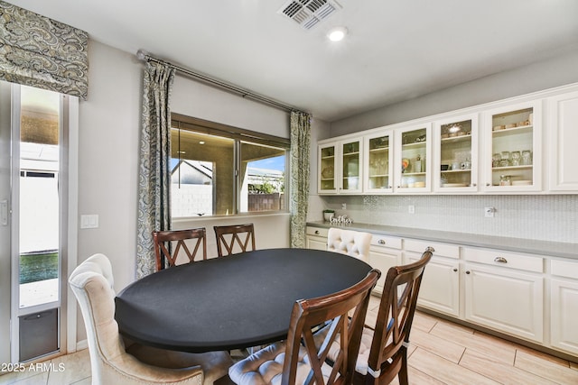 dining room featuring wood tiled floor and visible vents