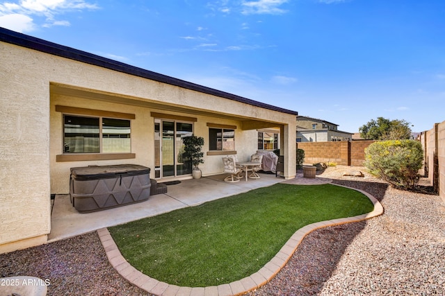 back of house featuring a patio area, a fenced backyard, a yard, and stucco siding