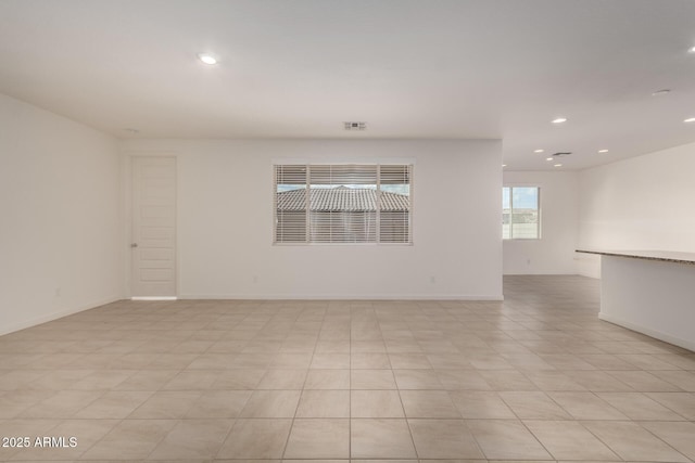 unfurnished room featuring baseboards, visible vents, and recessed lighting