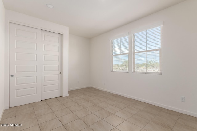 unfurnished bedroom with baseboards and a closet