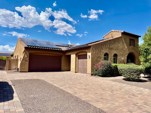 view of front facade with solar panels and a garage