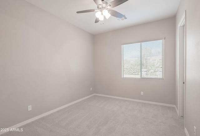 empty room featuring baseboards, a ceiling fan, visible vents, and light colored carpet