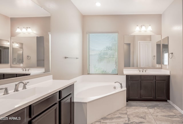 full bathroom with a bath, marble finish floor, two vanities, and a sink