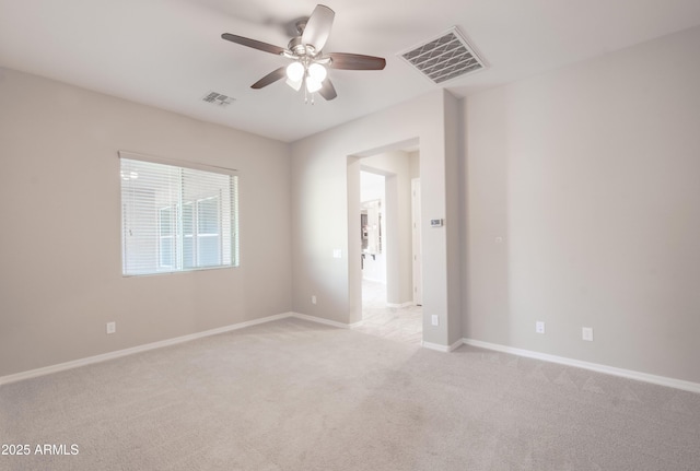 empty room with visible vents, ceiling fan, light carpet, and baseboards