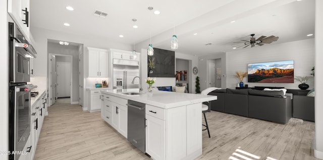 8149 E Jaeger St, Mesa, AZ 85207 - kitchen featuring a sink, open floor plan, stainless steel appliances, light wood-type flooring, and a kitchen breakfast bar