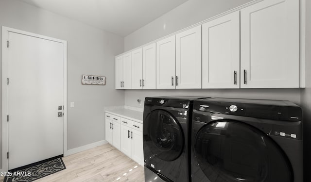 8149 E Jaeger St, Mesa, AZ 85207 - laundry room with washing machine and dryer, cabinet space, light wood-style flooring, and baseboards