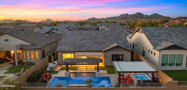 8149 E Jaeger St, Mesa, AZ 85207 - back of property at dusk with a fenced backyard, a mountain view, a residential view, stucco siding, and a patio area
