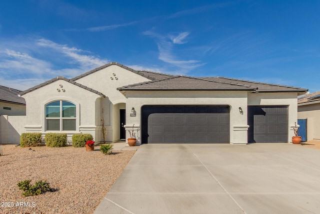 view of front of house with a garage, a tile roof, driveway, and stucco siding