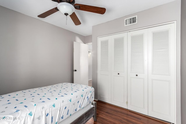 bedroom with dark hardwood / wood-style flooring, a closet, and ceiling fan