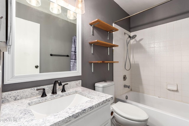 full bathroom with vanity, tiled shower / bath combo, and toilet