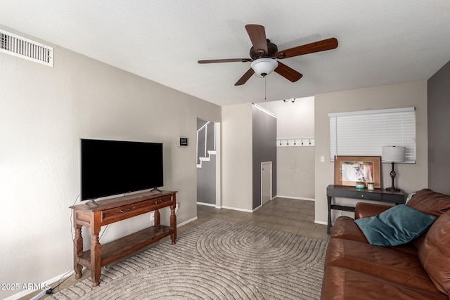 living room with dark tile patterned flooring and ceiling fan