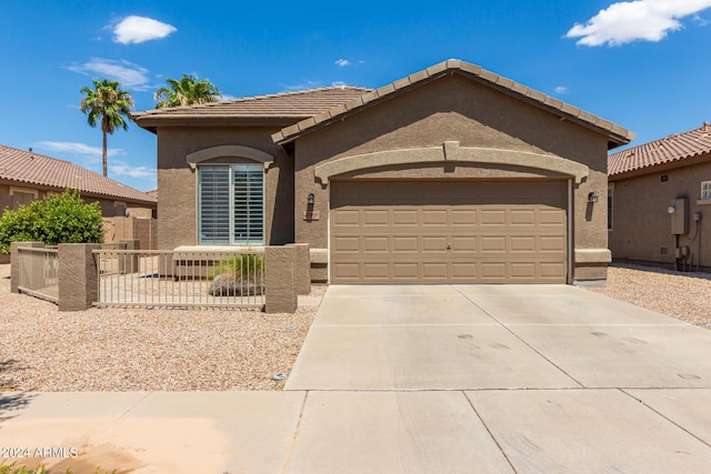 single story home with a tile roof, stucco siding, concrete driveway, an attached garage, and fence