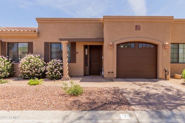 4241 N Pebblecreek Pkwy Unit 7, Goodyear, AZ 85395 - pueblo-style home featuring an attached garage, stucco siding, decorative driveway, and a tiled roof