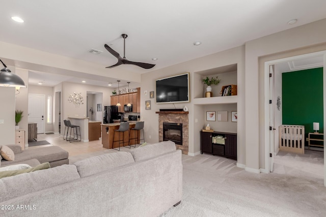 4241 N Pebblecreek Pkwy Unit 7, Goodyear, AZ 85395 - living area featuring a ceiling fan, light colored carpet, a fireplace, baseboards, and recessed lighting