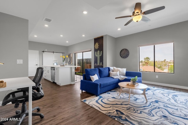 living room featuring a healthy amount of sunlight, ceiling fan, and dark wood-type flooring