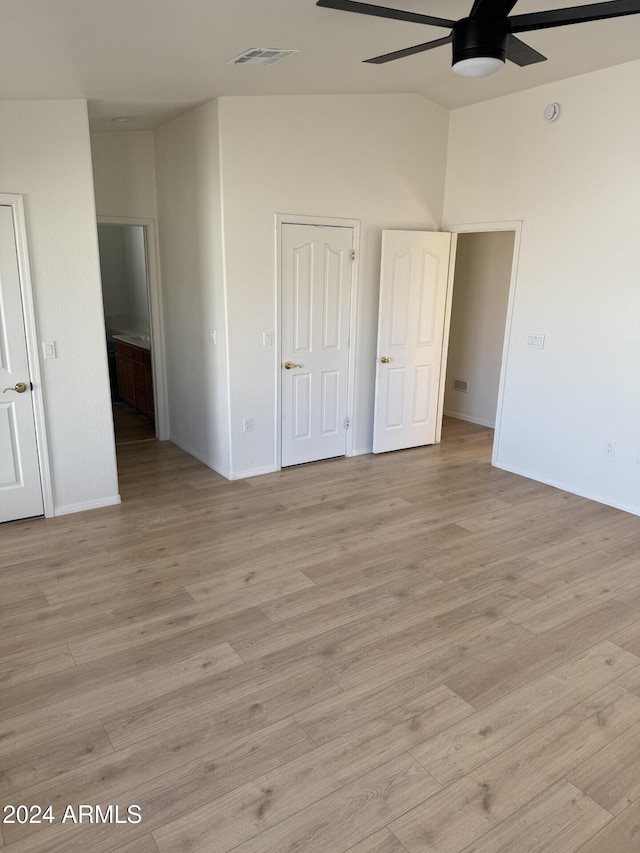 unfurnished bedroom with ceiling fan, light wood-type flooring, and vaulted ceiling