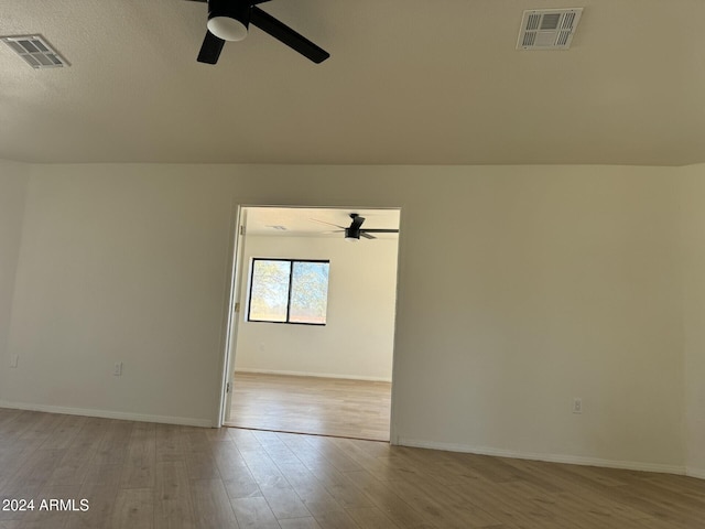 unfurnished room with ceiling fan, light hardwood / wood-style flooring, and a textured ceiling