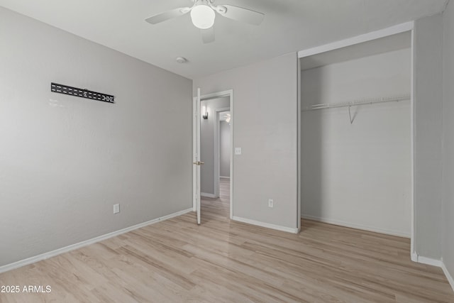 unfurnished bedroom with ceiling fan, light wood-type flooring, and a closet