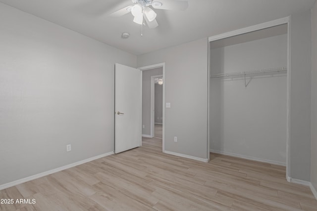 unfurnished bedroom with ceiling fan, light wood-type flooring, and a closet