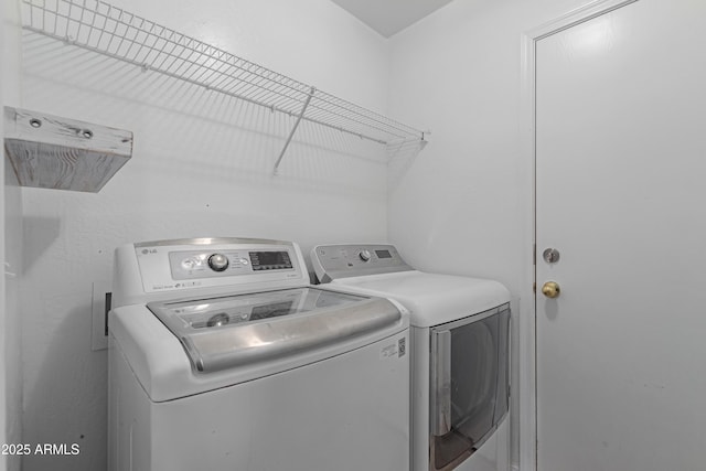 clothes washing area with washing machine and dryer