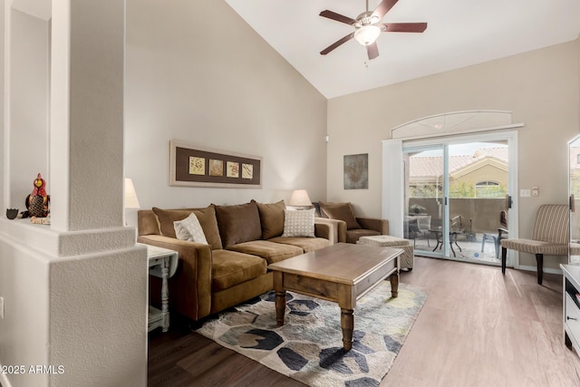 living room with wood finished floors, a ceiling fan, and high vaulted ceiling