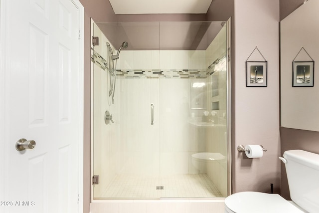 bathroom with a shower stall and toilet