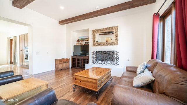 living room featuring wood-type flooring and beam ceiling