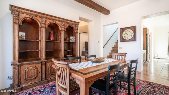 dining room with wood-type flooring and beamed ceiling